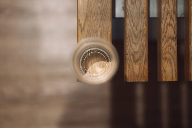 plastic glass with clean water on wooden bench top view with blurred background.