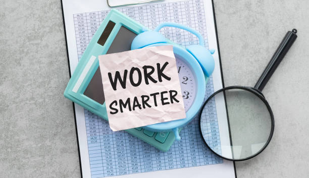 istock work smarter text on a pink card on the background of reports on the table. 1373003049