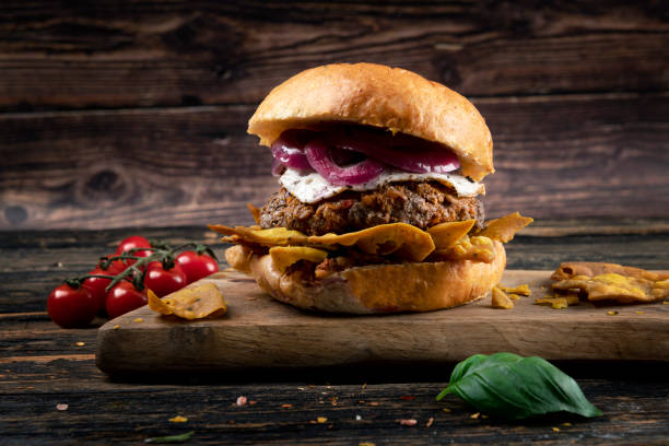 Nacho Cheeseburger with tomato and lettuce on wooden board