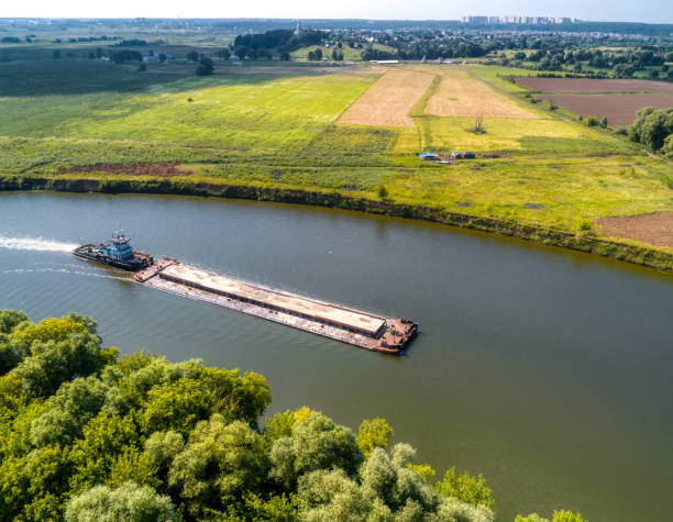 istock Towboat transports barge with sand along tranquil river 1373004371