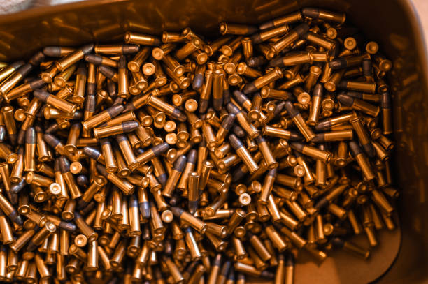 Heap of black and golden small-caliber bullets on table