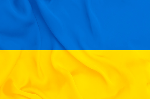 Smooth waving satin material colorised in yellow and blue, the colors of Ukrainian flag.