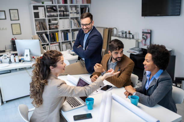 Four business colleagues sharing some business ideas about new architecture project in the office stock photo