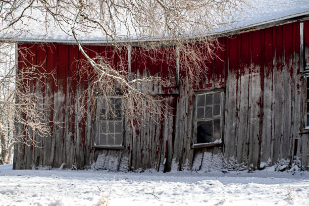 Falling snow and a red barn surround in snow seen in rural North Carolina