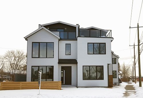 Calgary, Alberta, Canada- February 26,2022:  New modern 3 storey home built to replace an older home in an old established neighborhood.