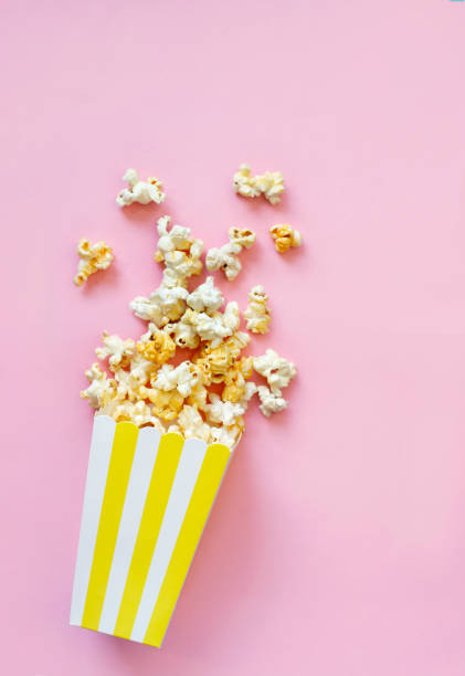 istock Spilled popcorn on pink background. Movie night concept. Copy space for text 1373012562