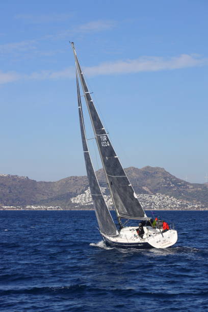 segelboote segeln bei windigem wetter im blauen wasser der ägäis - sailboat storm teamwork competition stock-fotos und bilder