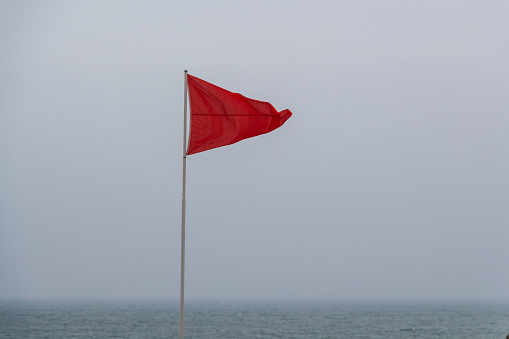 Red flag in Ris beach in Douarnenez during a stormy day