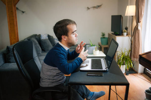 istock Young man with dwarfism working from home 1373021888