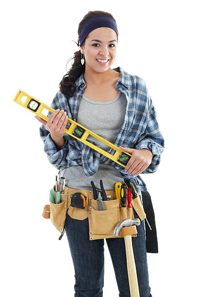 Handywoman smiling isolated on white background Stock image of handywoman isolated on white background woman wearing tool belt stock pictures, royalty-free photos & images