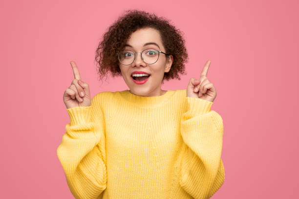 istock Excited young woman pointing up 1373029129