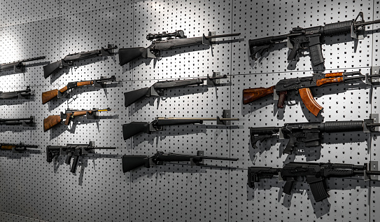 Colección de fusiles y carabinas. Varias armas de fuego cuelgan de soportes especiales en la pared. Fondo de armas. photo