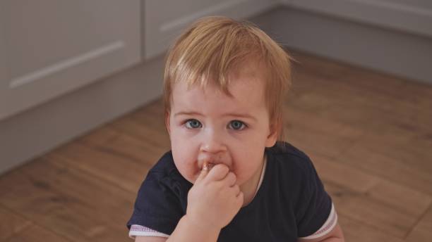 süße entzückende kaukasische kleinkind baby mädchen essen riegel süße milchschokolade bekommt ihr gesicht schmutzig - child obesity stock-fotos und bilder