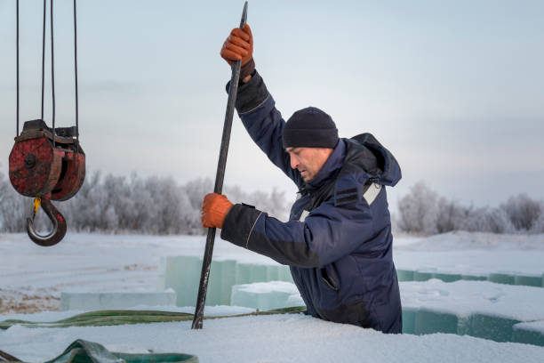 An installer with a metal crowbar in his hands Worker with scrap metal in his hands loading ice blocks frozen river stock pictures, royalty-free photos & images