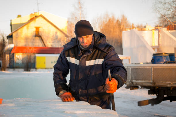 Worker at the construction site of the ice town with a crowbar in his hand