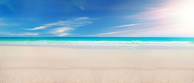 Seascape beach background. Blue sea in clear sky day on the tropical seashore in Thailand. Focus on sand foreground.