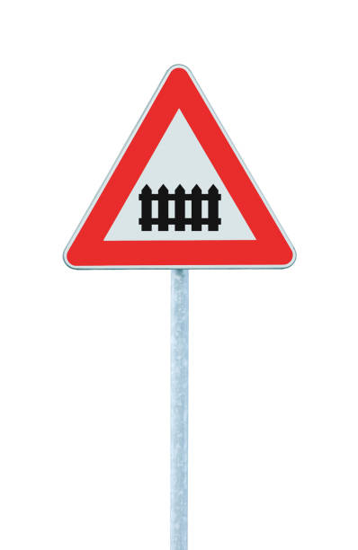 istock Railroad level crossing with railway barrier or gate ahead road sign, isolated grey pole post, roadside traffic triangle signage, large detailed vertical closeup 1373047665