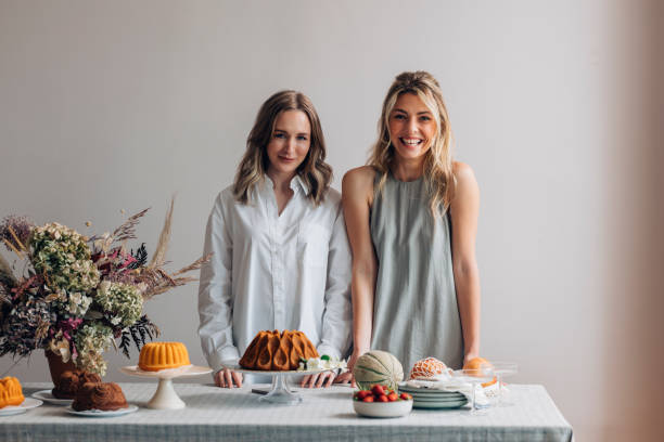 istock Two Smiling Female Friends Having Fun while Setting the Table for a Birthday Party (Looking at Camera) 1373050281