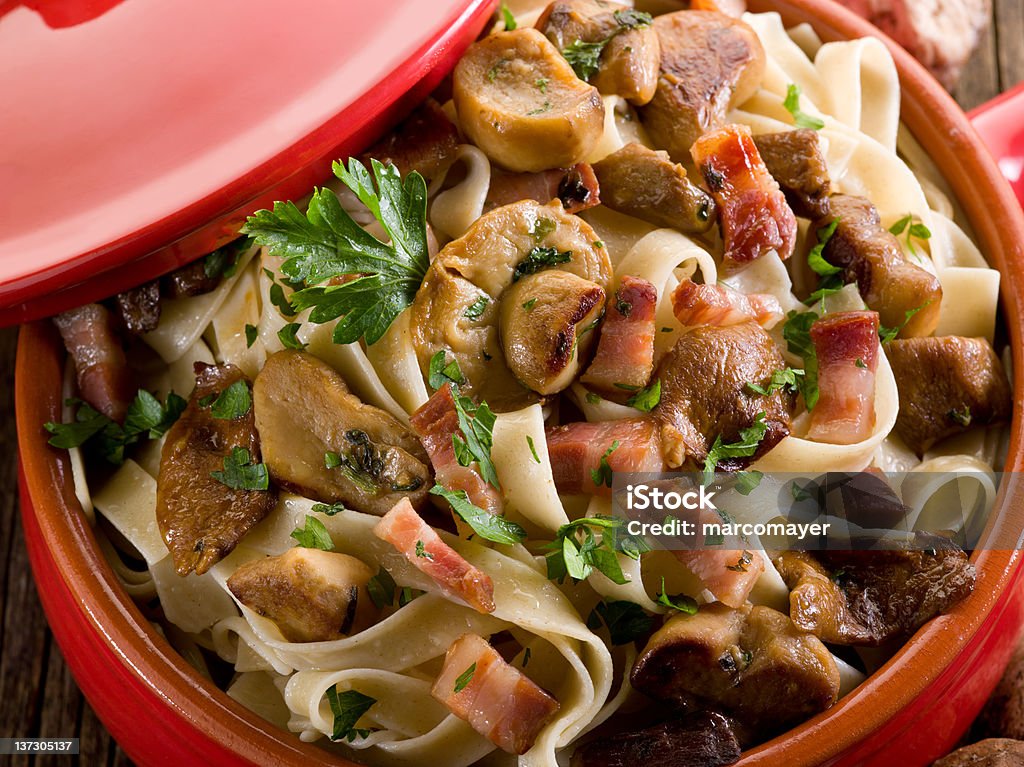 tagliatelle with cep edible mushroom and bacon over casserole Bacon Stock Photo