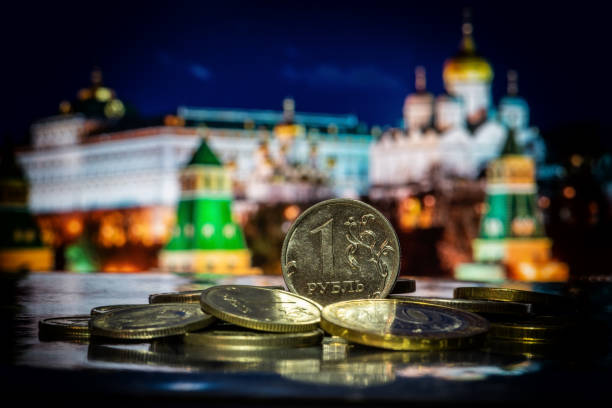 münze im wert von 1 russischen rubel auf einem stapel anderer münzen vor symbolischen unscharfen fragmenten des moskauer kremls - moscow russia stock-fotos und bilder