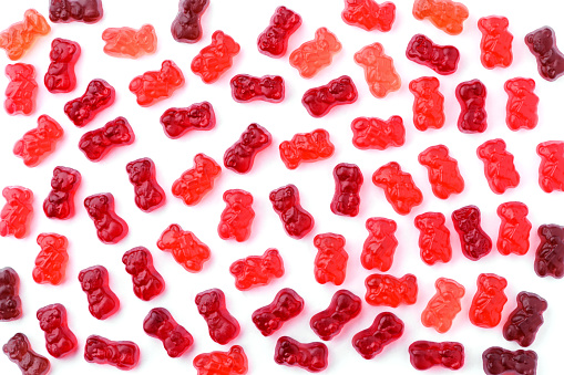 Small gummy bears red and brown on a white background