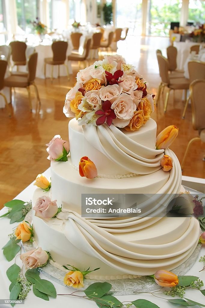 Beautiful white wedding cake with roses. White wedding cake with roses on reception table. Adult Stock Photo