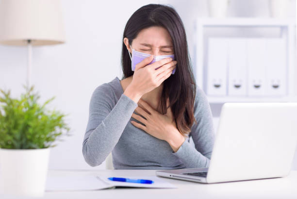 Stressed young  woman wearing medical face mask and working at home office - fotografia de stock