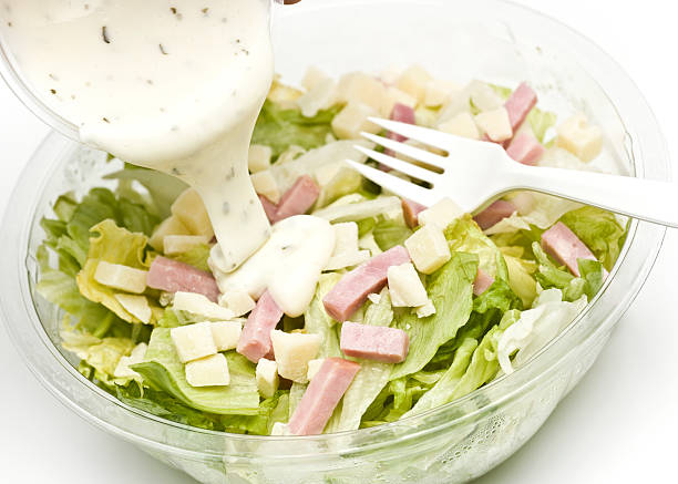 salad with bits of ham and dressing being poured over Small Chef Salad on white background (this picture have been shot with a Hasselblad HD3 II 31 megapixels) ranch dressing stock pictures, royalty-free photos & images