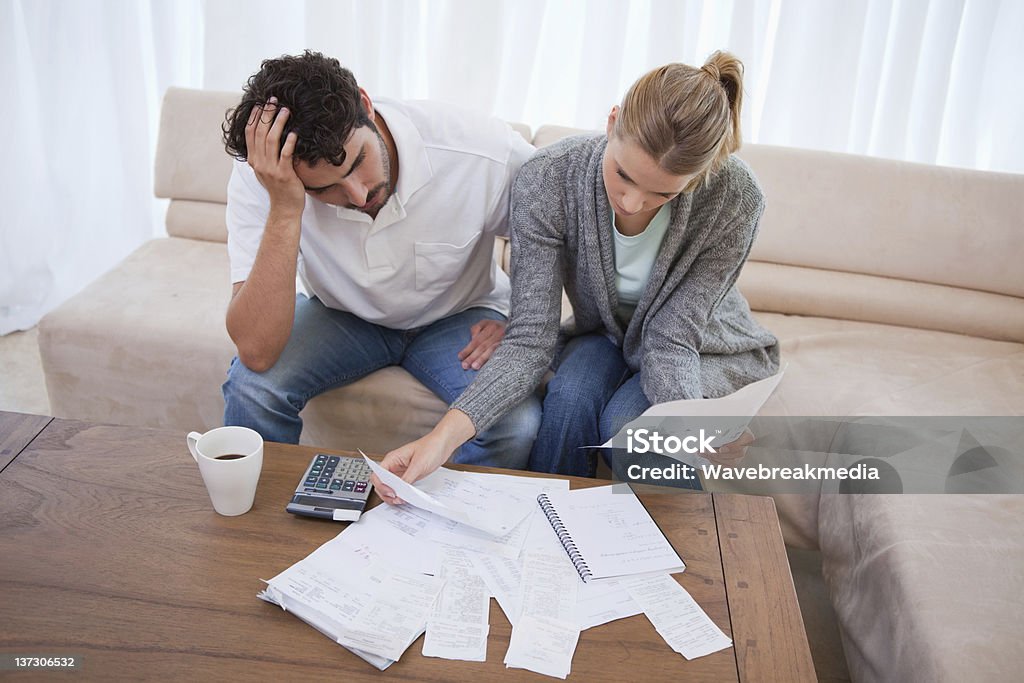 Depressed couple doing their accounting Depressed couple doing their accounting in their living room Problems Stock Photo Depressed couple doing their accounting Depressed couple doing their accounting in their living room Problems Stock Photo