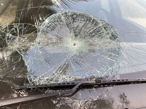 Shattered cracked broken damaged crashed car windshield a car accident. Dangerous, careless, unsafe, drunk, impaired driving, DUI, car crash injury fatality concept.