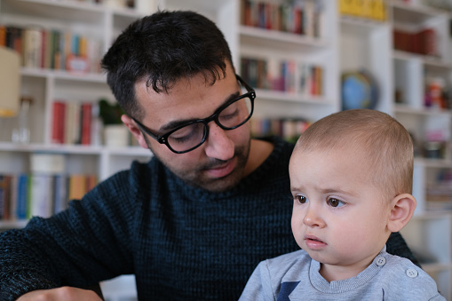 man working at home spends time with his son