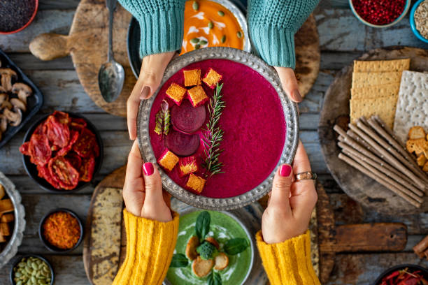 Two women drinking their beetroot soups.