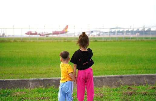 The children were excited and happy to see the planes take off and land beside the airport.