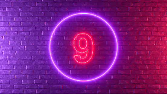 Number 9 with glowing neon lighting on black brick wall