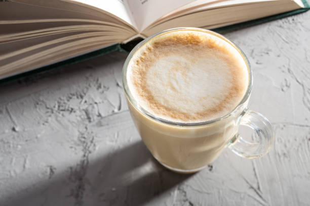 istock transparent cup of coffee with Latte art on concrete table with book 1373083841