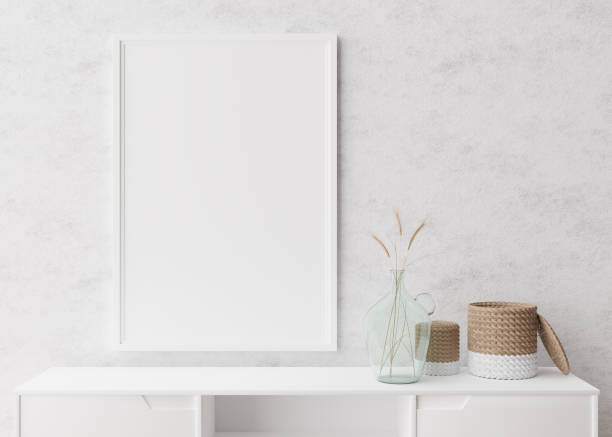 istock Empty vertical picture frame on white wall in modern living room. Mock up interior in minimalist, scandinavian style. Free space for picture. Console, rattan basket, dried grass in vase. 3D rendering. 1373084741