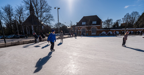 Outdoor ice-skating in the low winter sun in Frederiksberg,\nFrederiksberg is an autonomous municipality within Copenhagen