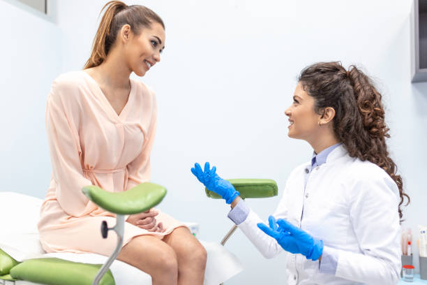 Gynecologist talking with a young female patient during a medical consultation in the gynecological office Gynecologist talking with a young female patient during a medical consultation in the gynecological office cervical cancer photos stock pictures, royalty-free photos & images