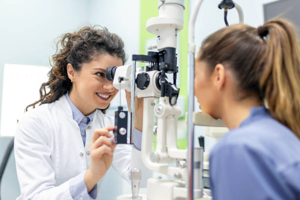 ophtalmologiste avec une patiente lors d’un examen dans une clinique moderne. l’ophtalmologiste utilise un équipement médical spécial pour sauver et améliorer la santé oculaire. - optométrie photos et images de collection