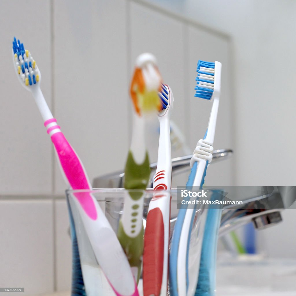 Toothbrushes in the bathroom A group of toothbrushes in a glass, standing in the bathroom. Domestic Bathroom Stock Photo