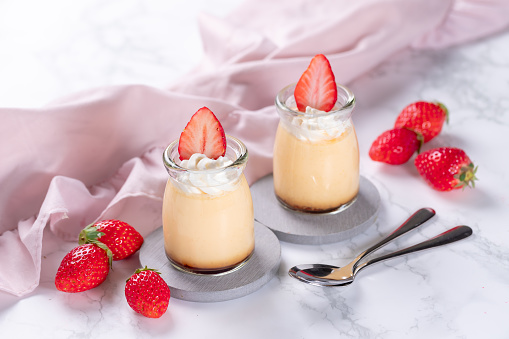 Creme caramel dessert or flan decorated with whipped cream and strawberry