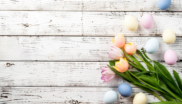 istock easter background with eggs and tulips on white wooden backdrop, top view flat lay 1373092918