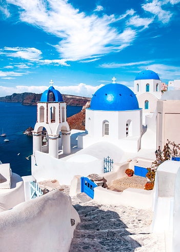 Traditional and famous houses and churches with blue domes over the Caldera, Oia, Santorini, Greece island, Aegean sea. Beautiful view of White Greek architecture. Travel, Famous travel destination.