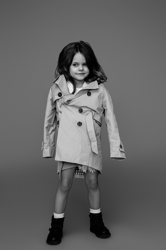 Cute little girl wearing white dress and coat