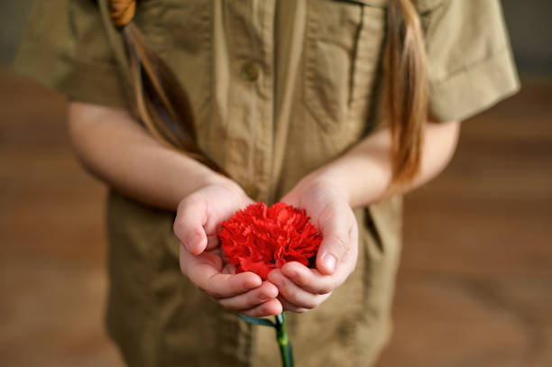 그녀의 손에 카네이션 꽃을 들고 있는 어린 소녀 - dianthus 뉴스 사진 이미지