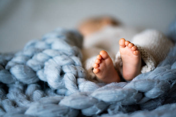 Foot of newborn baby Foot of newborn baby on warm blanket newborn stock pictures, royalty-free photos & images