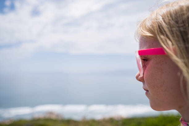 A cute girl with pink glasses at the beach