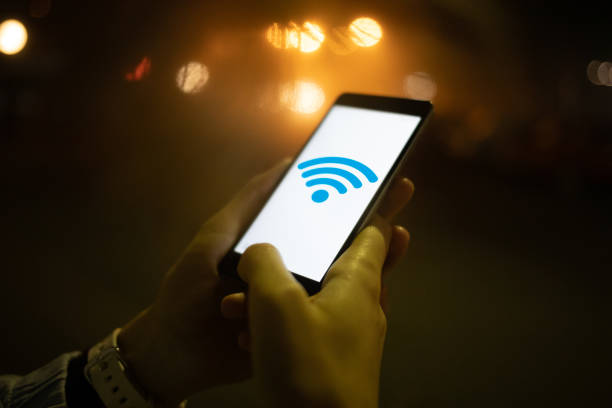 istock Woman connects to wifi using smartphone outdoors 1373103261