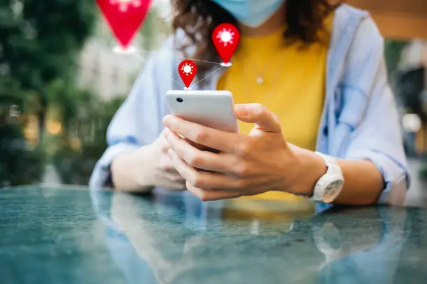 Photo of COVID-19 tracking app concept with geolocation icons pop up