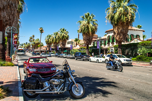 Palm Springs, CA, - June 21:  Palm tree lined street with motorcycles and many businesses in Palm Springs California.